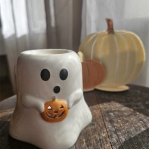 Brûle-parfum fantôme blanc tenant une citrouille orange, vue de face